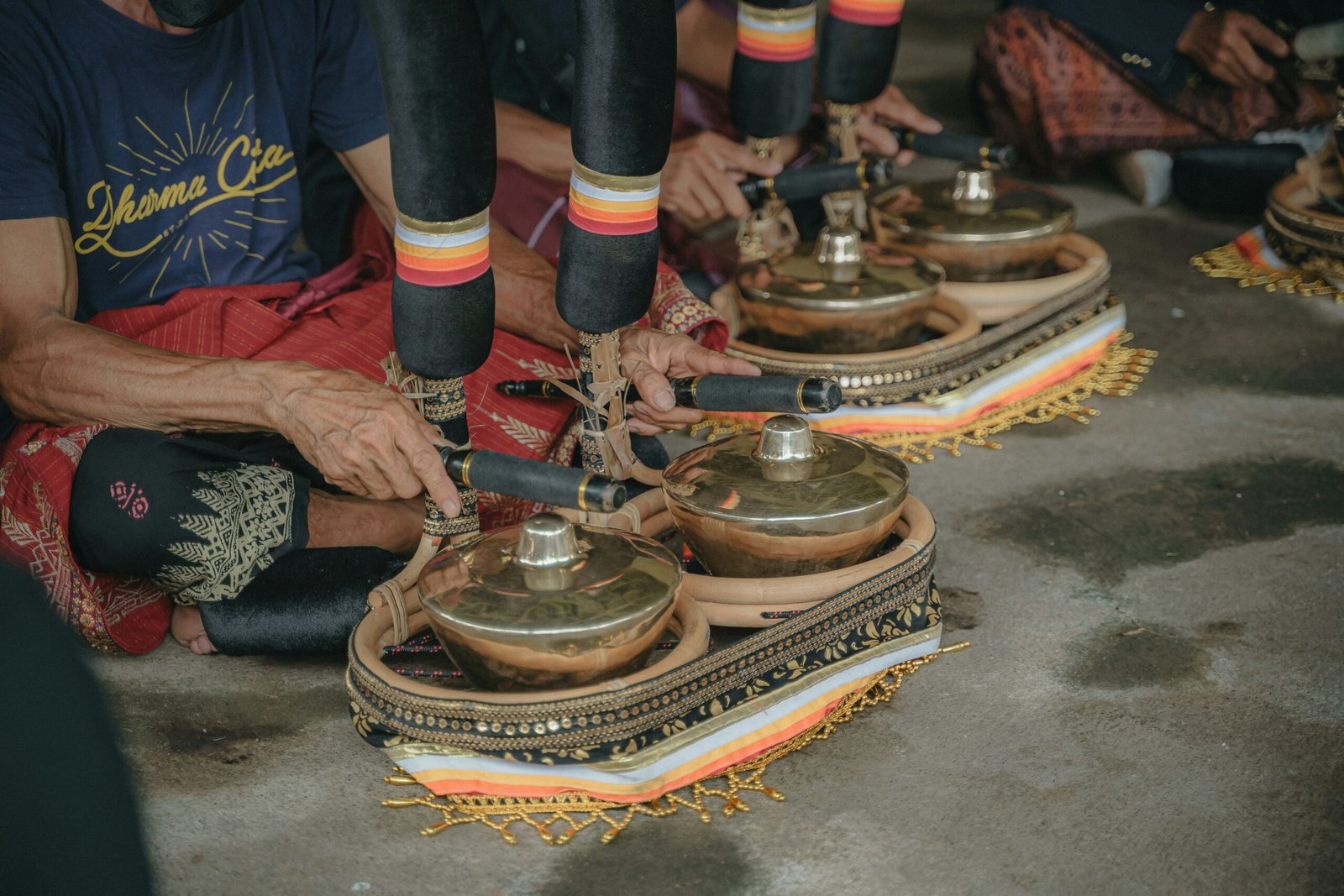 a group of people sitting on the ground with bells